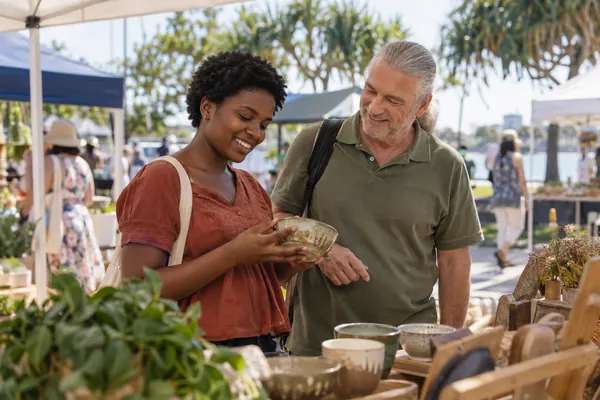 Support worker and young adult browsing stalls at a local community market