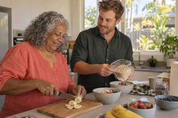 Support worker helping a participant prepare breakfast in her own kitchen
