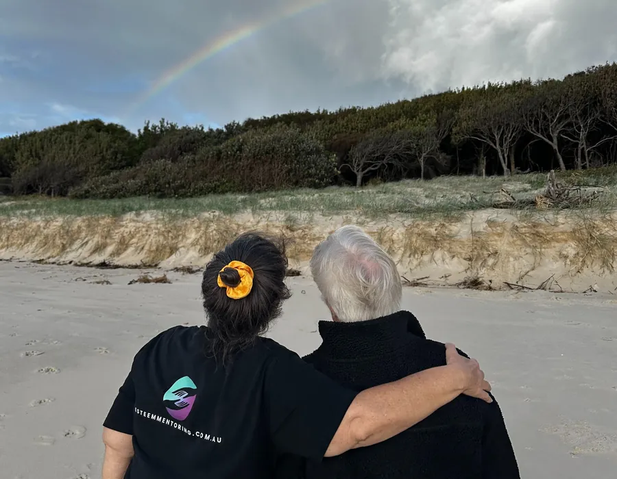 Esteem Mentoring support worker with her arm around a participant on the beach